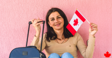 Female Holding Canadian Flag and Carry-on luggage - Relocation Pathways To Canada